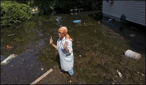 Judith Stampley, 71, stands in water in what should be the front yard of her Vicksburg, Miss., home.