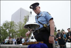 Toledo police Officer Robert Adams rings a bell as the names of area officers killed in the line of duty are read. Of the 65 honored, 30 were Toledo officers. Names dated back as far as March 5, 1880, and were as recent as March 19, 2011.