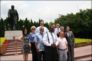 Toledo Mayor Mike Bell stands between his father, Norman Bell, and Wu King Hung, one of the investors who bought The Docks restaurant complex in East Toledo, in front of a statue of the late Chinese leader Deng Xiao-ping, known for revolutionizing China’s economy.