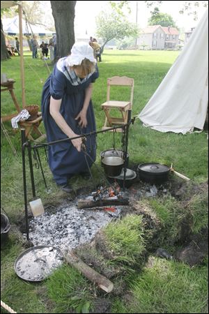 Cathy Taylor of Taylor,MI. cooks over an open flame during the open house. 