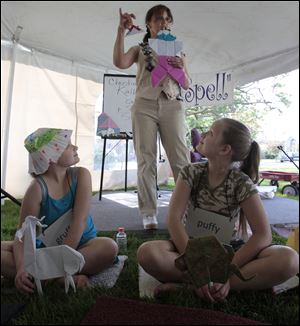 Toledo twins Elizabeth, left, and Addison Baker, 10, watch Christine Kallevig as she tells a storigami.