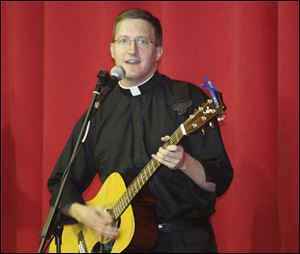 Father Jeff McBeth leads the assembled in singing during the celebration.