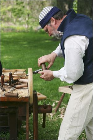 Wood worker Jim Crammond uses period appropriate tools to work on a stool.