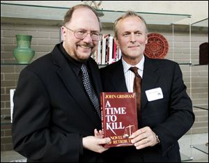 Writer John Grisham, right, and playwright Rupert Holmes pose for photographers with Grisham book 'A Time to Kill,' during the opening of the world premier of the stage adaption of 'A Time To Kill.'