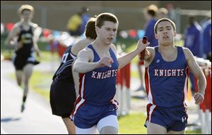 Dan Lenhart, left, takes the baton from Will Cameron during the final leg of the 3200 relay during the  St. Francis de Sales Knights Relay. The Knights' team, which also includes Will Cameron's brother, John, and Larry Jajou, won the race.