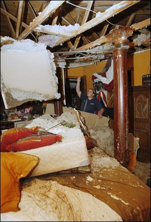 Rochelle Robertson is pictured in the rubble of her parents' bedroom in their home in Piedmont, Okla., following a tornado.