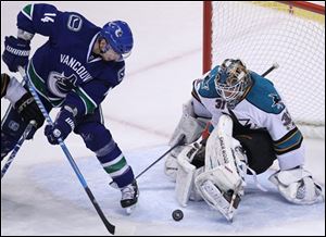 Sharks' goaltender Antti Niemi makes a save on a shot by the Canucks' Alex Burrows.
