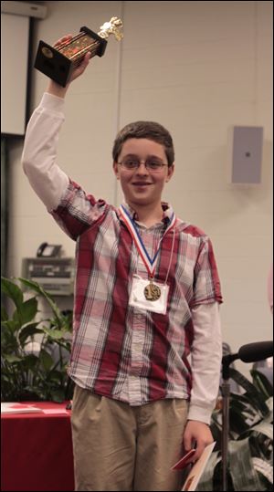 Whiteford Middle School student Zachary Ott, 14, holds up his trophy after winning the Monroe County Spelling Bee. 