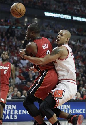 Miami Heat guard Dwyane Wade, left, is fouled by Chicago Bulls guard Keith Bogans during the first quarter of Game 5.