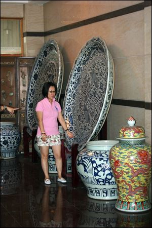 Dashing Pacific Chairman Yuan Xiaohong examines ancient Chinese artifacts owned by Yuan Jinkang, owner of Shaoxing Huitong Battery Co. Ltd near Hangzhou, China. 
