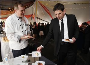 Greg Helyer selects some offerings from Toledo Club Chef Mike Rosendaul at Taste of the Nation.
