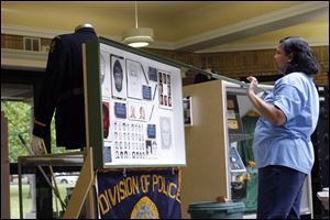 Toledo Police Officer Penny Halcomb closes the case on an exhibit after preparing it for viewing before the opening of the Toledo Police Museum.