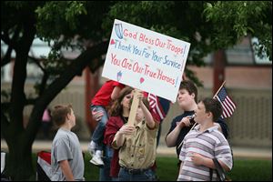 Eli Tomes, 11, of Boy Scout Troop 57 holds up a placard of thanks along the parade route.