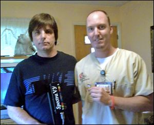 John Polcyn, left, found the camera memory card held by Michael Crane while using a metal detector at a Maumee Bay State Park beach. 