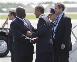 Toledo mayor Mike Bell greets President Barack Obama at Toledo Express Airport on Friday. At right is Ohio Sen. Sherrod Brown.