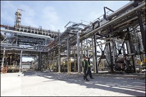 Employees walk through the grounds at the Husky Lima Refinery, a 1,100- acre complex that employs 430 hourly workers.