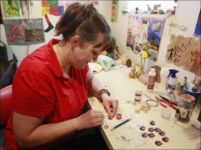 Tracy Swartz, a stay-at-home mom from Lake Township, works on her gourd art that is going to be part of the MTV Movie Awards celebrity swag bags. Mrs. Swartz supplied 95 pins for the bags. The awards ceremony marks the first event for her artwork. 