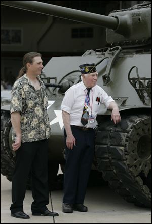 Norman Powers, of Helena, left, and his father, Norman Powers, of Gibsonburg, wait for a WWII bomber to arrive at the WWII Stage Door Canteen event.