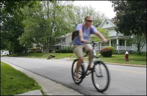 A bicyclist heads north on Summit Street near Orchard Drive. Sylvania City Precinct 4 includes the downtown business district and surrounding residences that date back to the city’s early days.