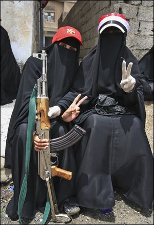 Female protesters pose with an AK-47 during a rally in Taiz demanding the ouster of Yemen's president.
