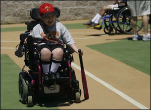 Alivianna Gallup, 5, who has spinal muscular atrophy, tools to first base in her motorized wheelchair, where she can stow her gear when not playing ball. She hit a home run in Sunday’s All-Star game.