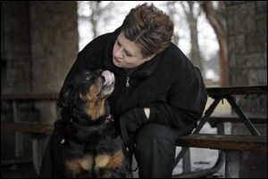 In this photo taken in March, Darby the Rottweiler receives some loving attention from Mona Guinaugh of South Toledo, who fostered the 7-year-old dog after the rescue and later adopted her. 