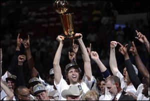 The Mavericks' Dirk Nowitzki holds up the championship trophy after Game 6 of the NBA finals against the Miami Heat.