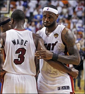 Miami Heat's LeBron James hugs teammate Dwyane Wade (3) after Game 6 of the NBA finals against the Dallas Mavericks.