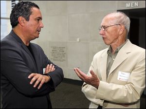 Mehrdad Yazdani, left, architect for the federal courthouse, talks with Toledo architect Bob Seyfang before Mr. Yazdani's presentation at the main Toledo-Lucas County Public Library downtown.