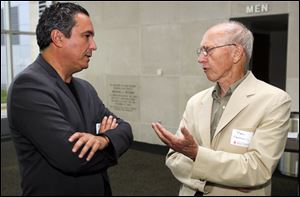 Mehrdad Yazdani, left, architect for the federal courthouse, talks with Toledo architect Bob Seyfang before Mr. Yazdani's presentation at the main Toledo-Lucas County Public Library downtown.