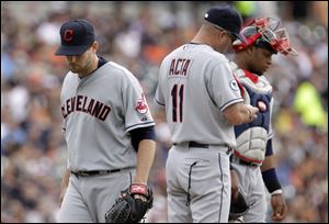 Cleveland Indians starting pitcher Mitch Talbot walks back to the dugout as manager Manny Acta (11) and catcher Carlos Santana wait for his relief in the fifth inning of a baseball game against the Detroit Tigers in Detroit, Thursday, June 16, 2011.