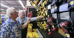 Larry Tomasik, left, of Carleton, Mich., looks at power tools with hardware salesman Dennis Vaughn at The Andersons in Toledo. 