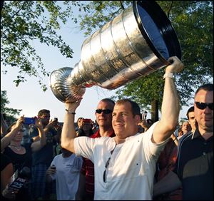 Mark Recchi carries the Stanley Cup aloft as he walks through a crowd of onlookers in Boston.