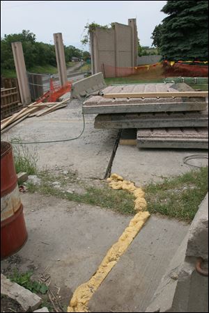 Shifting ground caused one slab of concrete on Sherbrooke Road to sink. Work on an I-475 retaining wall nearby stopped, but the rest of the project continues.