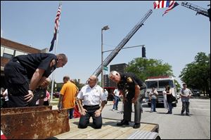 Richard Browne, left, of the Perrysburg Fire Department explains markings on the beam to Toledo Fire Department Chief Mike Wolever, center, and Lucas County Sheriff James Telb. Officer Browne went to New York with Wauseon officers to pick up the girder.