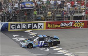 Denny Hamlin crosses the finish line to win the NASCAR Sprint Cup Series auto race at Michigan International Speedway in Brooklyn, Mich. on Sunday.