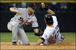 Tigers shortstop Jhonny Peralta (27) tags out the Rockies' Todd Helton (17) at second during the sixth inning.