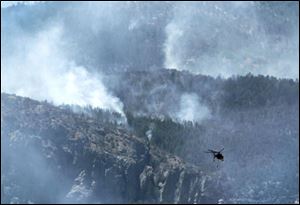 The battle against the Monument fire takes to the air Monday. Air crews had been grounded for most of Sunday. Firefighting efforts have been dogged for days by hot, windy weather. 