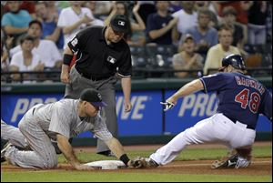 Colorado Rockies third baseman Ty Wigginton, left, tags out Cleveland Indians' Travis Hafner (48) trying to go first to third on an RBI-single by Shin-Soo Choo in the sixth inning.