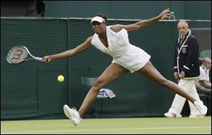 Venus Williams stretches to make a shot against Kimiko Date-Krumm of Japan in the second round Wednesday at Wimbledon. Williams advanced with a 6-7 (6), 6-3, 8-6 victory over Date-Krumm.