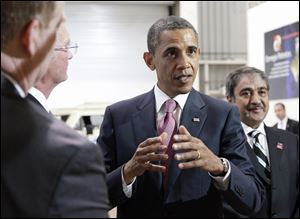 President Barack Obama talks to the media Friday during his tour of Carnegie Mellon University's National Robotics Engineering Center in Pittsburgh. The president is ramping up negotiations on the national debt.