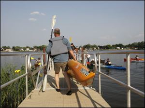 Scott Kolling totes a lightweight kayak down to Howard Pinkley landing on the Ottawa River.