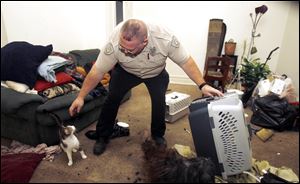 Officer Gene Boros, an animal cruelty investigator with the Toledo Humane Society, recovers a cat that was abandoned with two other cats and a dog.