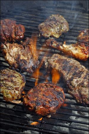 Lamb burgers, lamb chops, chicken and a strip steak on the grill.
