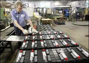 Bob Ritter stacks batteries for shipping at the Johnson Controls plant on Industrial Road near Toledo Express Airport. The company plans to convert production to batteries with new technology.