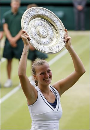 Petra Kvitova of the Czech Republic holds her trophy aloft after defeating Russia's Maria Sharapova in the ladies' singles final at the All England Lawn Tennis Championships at Wimbledon.