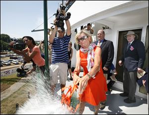 A hearty spray of champagne bursts from a broken bottle wielded by Treecie Schoonmaker, wife of James Schoonmaker II, far right, during yesterday's rechristening of the S.S. Col. James M. Schoonmaker.