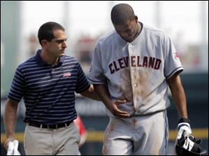 Trainer Lonnie Soloff, left, helps Cleveland Indians starting pitcher Fausto Carmona walk off the field with an undisclosed injury during a game against the Cincinnati Reds on Saturday.