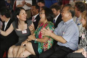 Amy Chang, associate principal cellist of the Toledo Symphony Orchestra and the Toledo Opera, and translator at the event for Tina Yuan, center, and Wu King Hung, right, both of Dashing Pacific. 
