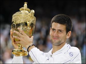 Serbia's Novak Djokovic lifts the trophy after defeating Spain's Rafael Nadal in the men's singles final at the All England Lawn Tennis Championships.